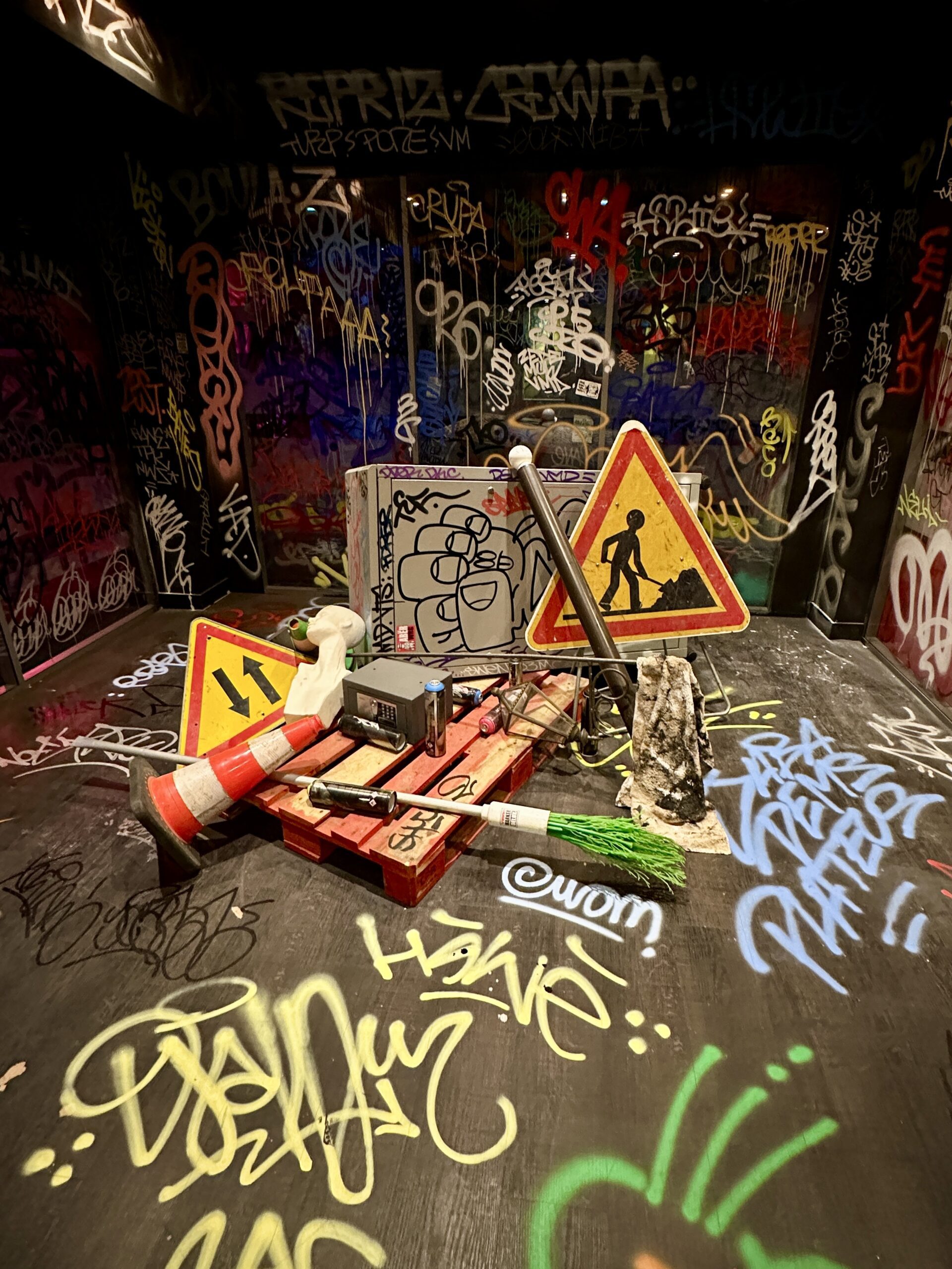 Installation de street art avec graffiti et panneaux de signalisation.